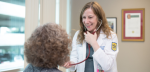 Photo of Marina Roytman, MD, caring for a patient.